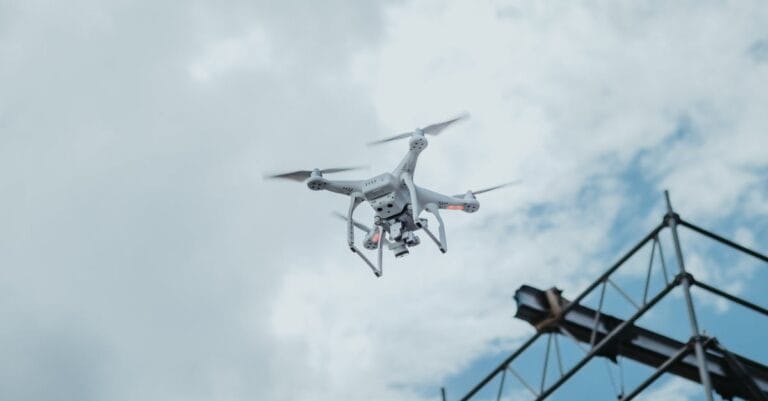 A drone hovering in the sky amidst clouds, showcasing technology in action.