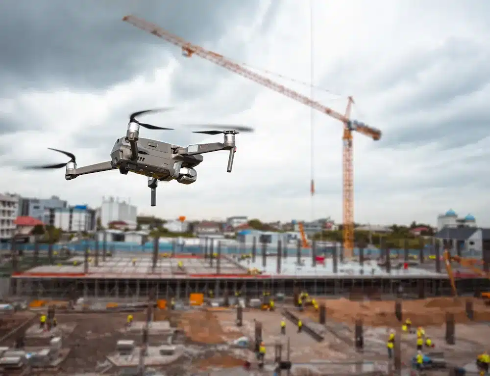 modern drone actively flying over a construction site, a large development area, or a landscape that clearly shows land features