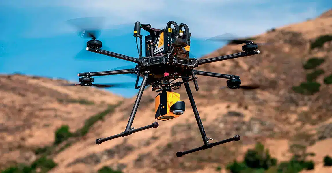 LiDAR drone performing a survey over varied UK terrain, showing laser lines penetrating trees to capture comprehensive ground data.