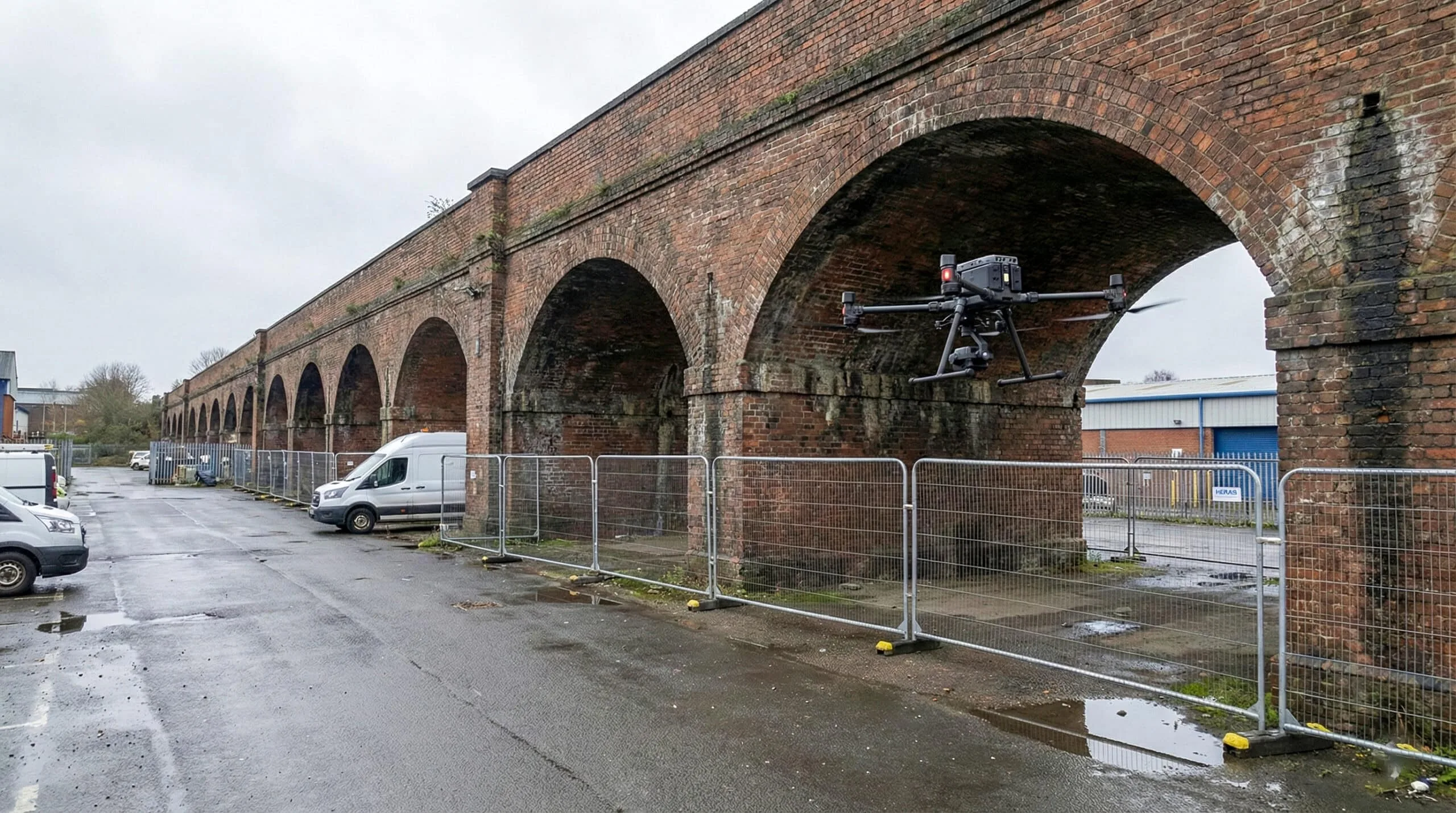 Survey drone positioned near historic brick railway viaduct arches for detailed structural inspection and documentation