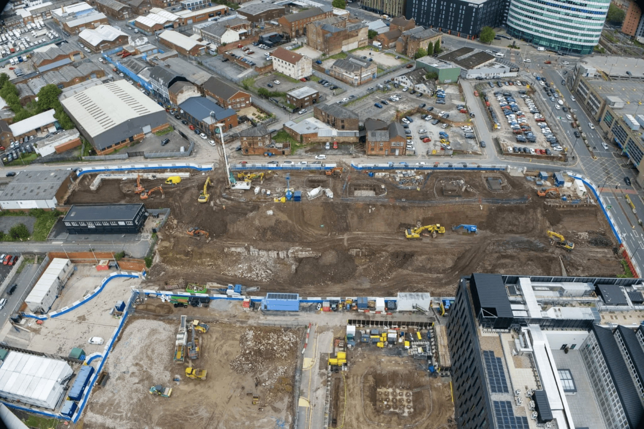 Aerial view of urban construction site showing earthworks and surrounding buildings captured during drone survey mapping