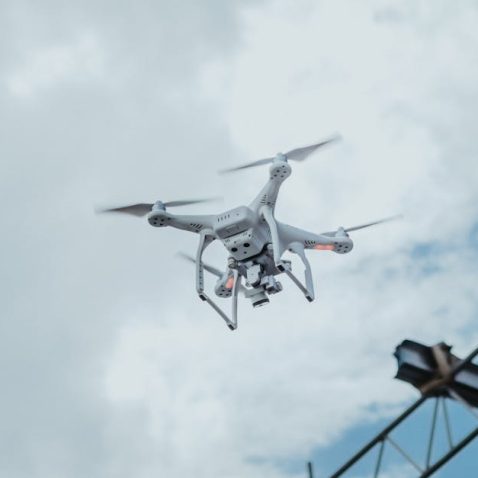 A drone hovering in the sky amidst clouds, showcasing technology in action.